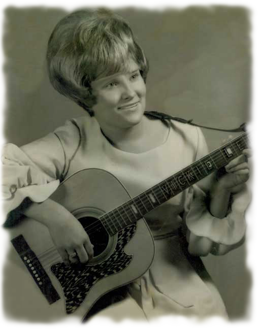 Vicki Lee performing with her guitar, early in her career